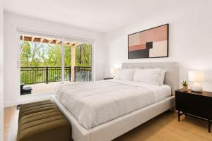 a bedroom with a large bed and a balcony at Spa - River - Game Room - Le Boreal in Mont-Tremblant