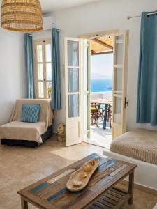 a living room with a table and a view of the ocean at Uranos studios Amorgos in Amorgos
