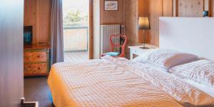 a bedroom with a bed and a chair and a window at Hotel Stocker in San Valentino alla Muta