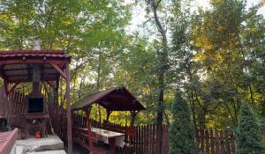 a wooden playground with a gazebo and trees at Hegyi-lak vendégház in Praid