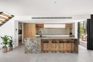 a kitchen with a large marble counter and stools at Luxury Retreat with Private Beach & Jetty in Noosa Heads