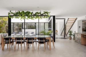 a dining room with a glass table and chairs at Luxury Retreat with Private Beach & Jetty in Noosa Heads