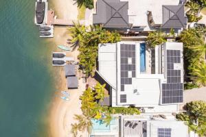 an overhead view of a house with solar panels on a beach at Luxury Retreat with Private Beach & Jetty in Noosa Heads