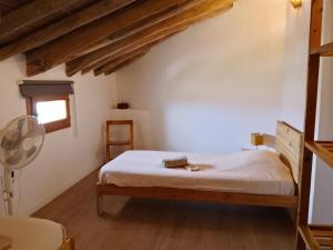 a bedroom with a bed with a fan and a window at Kortijo Martzala in Lucainena de las Torres