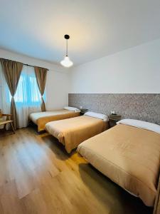 a hotel room with two beds and a window at Dos Romeiros in Palas de Rei
