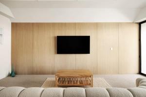 a living room with a table and a tv on a wall at Casa Six on Witta in Noosa Heads