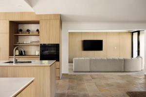 a kitchen with a couch and a television in it at Casa Six on Witta in Noosa Heads