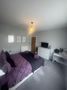 a bedroom with a purple bed and a desk at House Aurora in Edinburgh