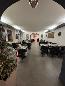 a dining room with tables and chairs and a clock at Hôtel-Restaurant Le Hauteville in Hauteville-Lompnes +13 photos