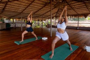 two women doing yoga in a yoga class at Palm Grove Beach Resort in Mandrem