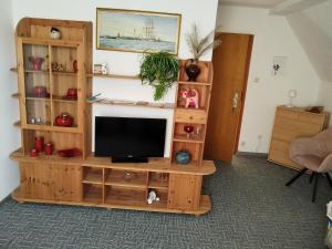 a living room with a television on a wooden entertainment center at König in Korswandt