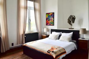 a bedroom with a large bed and a window at B&B Petit-Hallet in Hannut