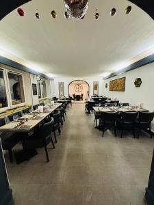 a dining room with tables and chairs and a chandelier at Hôtel-Restaurant Le Hauteville in Hauteville-Lompnes