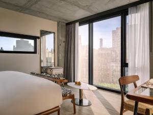 a bedroom with a bed and a large window at Merchant LES Hotel in New York