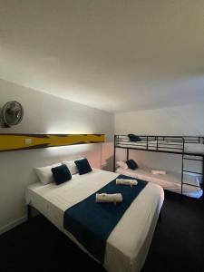 a bedroom with two beds and two bunk beds at hôtel du grand sud in Ramonville-Saint-Agne