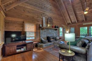 a living room with a large television and a fireplace at Oscars Outpost Fire Pit Pet Friendly in Mineral Bluff