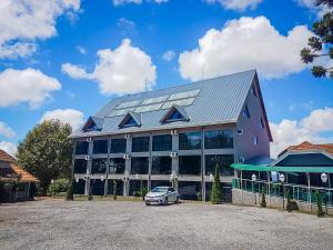 a building with a car parked in front of it at Hotel Castelo Nacional Inn Campos do Jordão in Campos do Jordão