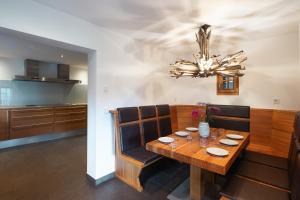 a dining room with a wooden table and a chandelier at Alpen Chalet Forest in Mauterndorf