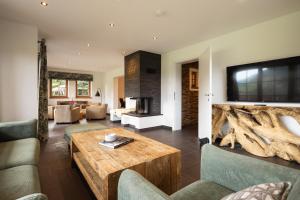 a living room with a table and a fireplace at Alpen Chalet Forest in Mauterndorf