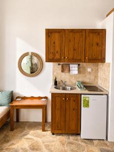 a kitchen with wooden cabinets and a sink at Uranos studios Amorgos in Amorgos