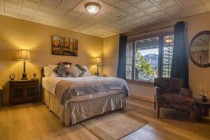 a bedroom with a bed and a chair and a window at Log Home with Lake View and Backyard in Invermere