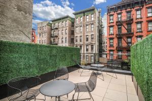 a patio with tables and chairs and buildings at Merchant LES Hotel in New York