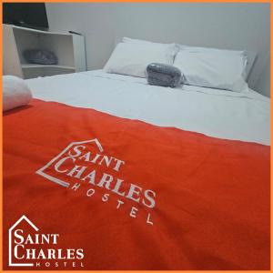 a bed with a red blanket on top of it at Saint Charles Hostel in São Carlos