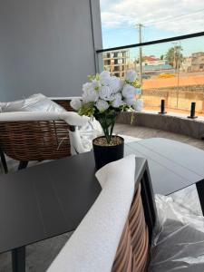 ein schwarzer Tisch mit einer Blumenvase darauf in der Unterkunft Tijania Complex in Bijilo