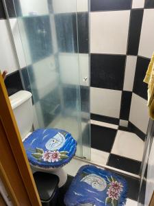 a bathroom with a toilet with blue and white tiles at Apartamento in Natal