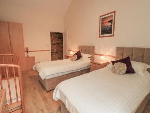 a hotel room with two beds and a staircase at The Hayloft in Wigton