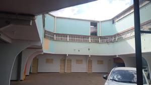 a building with a car parked in a parking lot at Hotel 1001 noites samambaia ADE in Brasília
