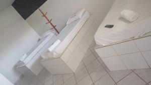 a bathroom with a tub and a toilet in a room at Hotel 1001 noites samambaia ADE in Brasília