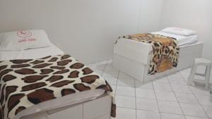 a bedroom with a bed with a leopard print blanket at Hotel 1001 noites samambaia ADE in Brasília