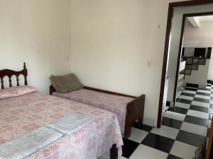 a bedroom with two beds and a checkered floor at Apartamento in Natal