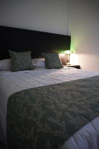a bedroom with a large bed with a black headboard at Hotel Makao in La Rosita