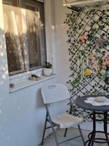 a chair and a table in front of a window at Apartman Mostar in Mostar