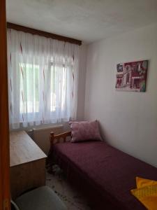 a small bedroom with a bed and a window at Apartman Mostar in Mostar