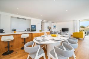 a kitchen and dining room with a white table and chairs at Vilamoura 4-Bedroom Penthouse with Jacuzzi in Vilamoura