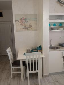 a kitchen with a table and chairs and a sink at Studio Dream 30m od plaze in Đenovići