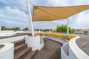a rooftop deck on a house with yellow pillows at Vilamoura 4-Bedroom Penthouse with Jacuzzi in Vilamoura