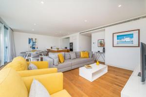 a living room with a yellow couch and a table at Vilamoura 4-Bedroom Penthouse with Jacuzzi in Vilamoura