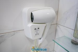 a white toilet in a white tiled bathroom at Hotel Meteor in Jupiter +54 photos