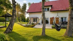 a house with a hammock in the yard at Agroturystyka Anna in Dąbki