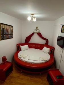 a red bed in a room with a red couch at Hotel Dona in Mamaia