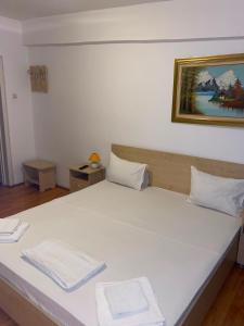 a large white bed with two white towels on it at Hotel Dona in Mamaia
