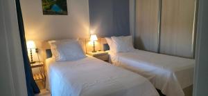 two beds in a room with white sheets and pillows at Marena B&B in Pogradec