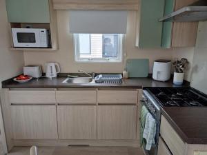 a kitchen with a sink and a stove top oven at Ruby'scumbrianholidaysforall SEN friendly in Carlisle