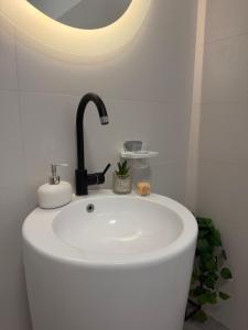 a bathroom with a white sink with a faucet at The cozy escape in Satu Bucovei +9 photos