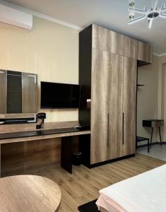 a room with a large wooden cabinet with a television at Van park hotel in Shymkent