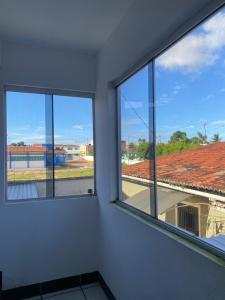 three windows in a room with a view of a building at Apartamento in Natal